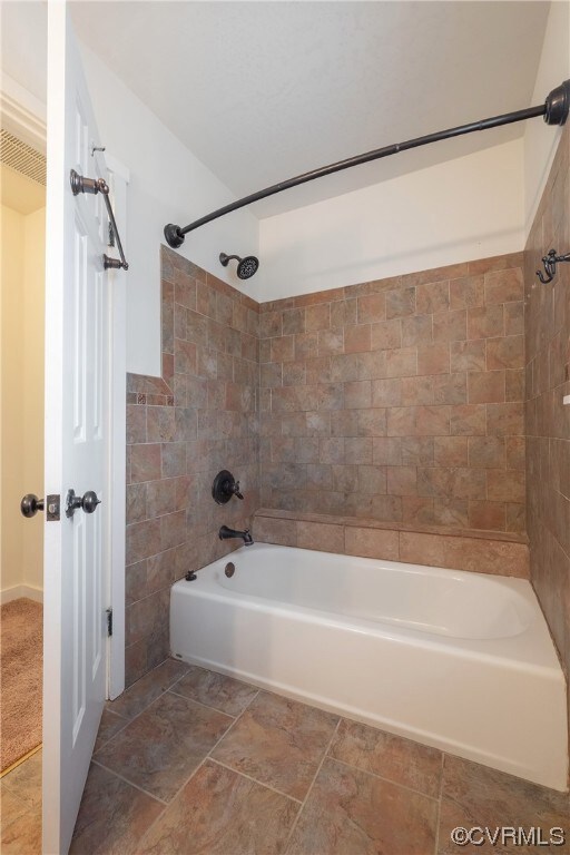 Bathroom featuring tiled shower / bath and tile fl