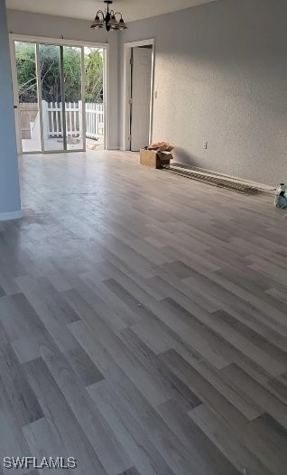 Empty room with a chandelier and wood finished flo