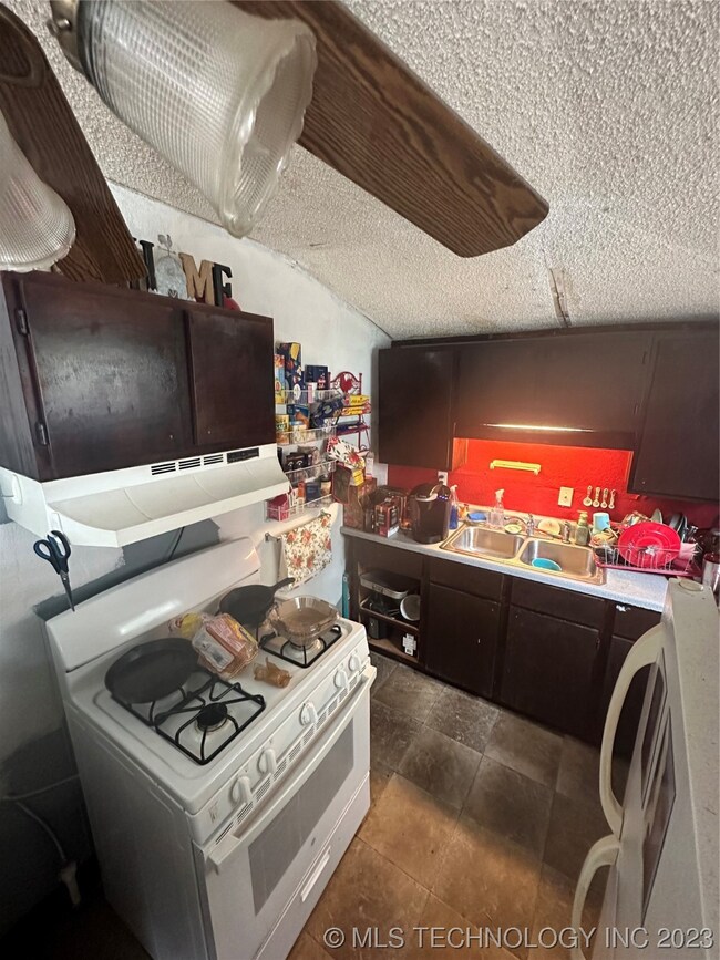 Kitchen has 4-burner gas stove/oven.  Ceiling dama