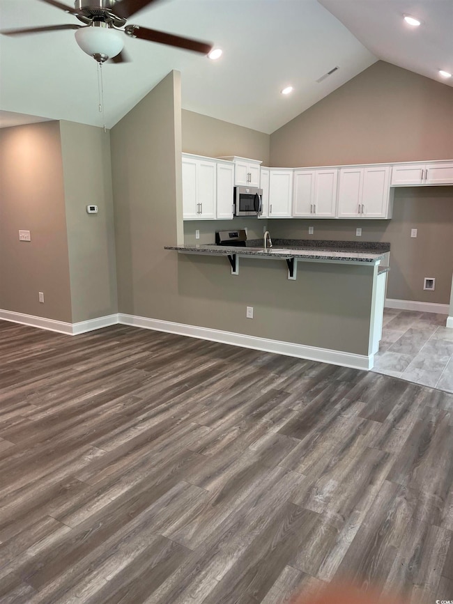 Kitchen with high vaulted ceiling, white cabinetry