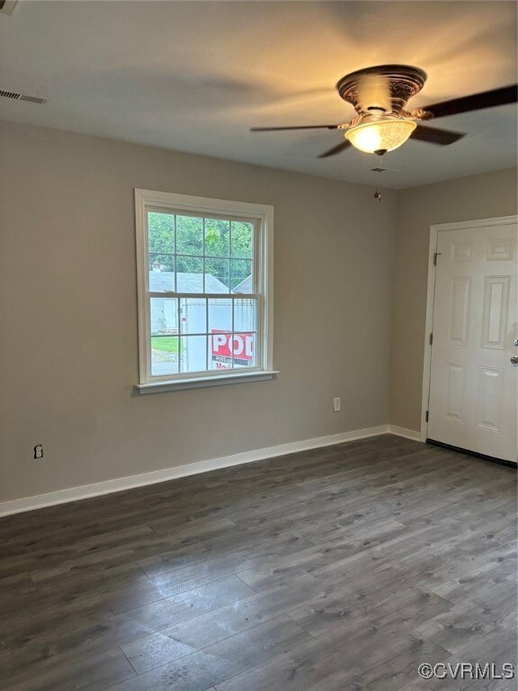 Spare room featuring wood finished floors, baseboa