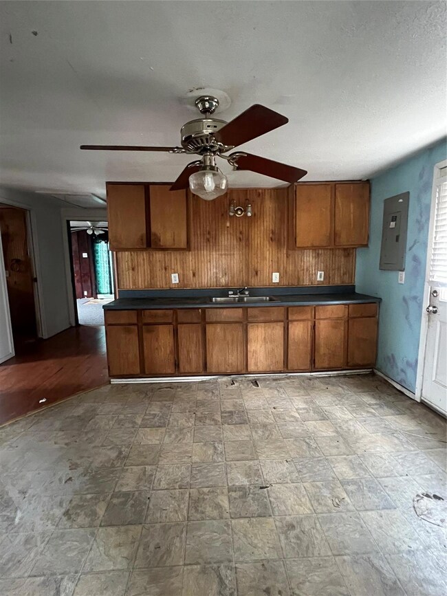 Kitchen with sink, electric panel, ceiling fan, an