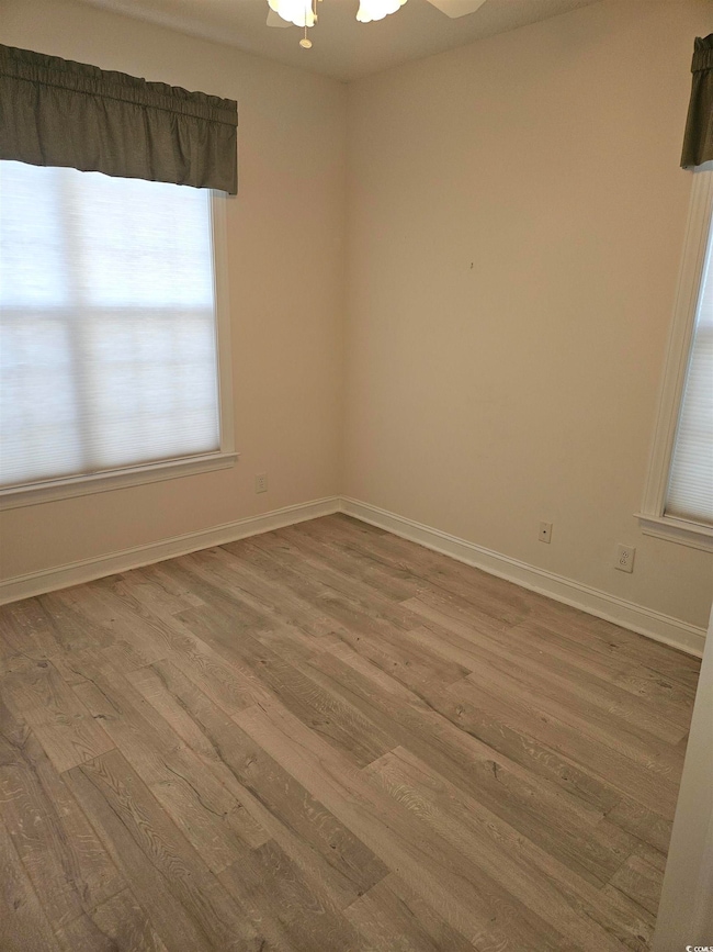 Spare room with light wood-type flooring and a ceiling fan