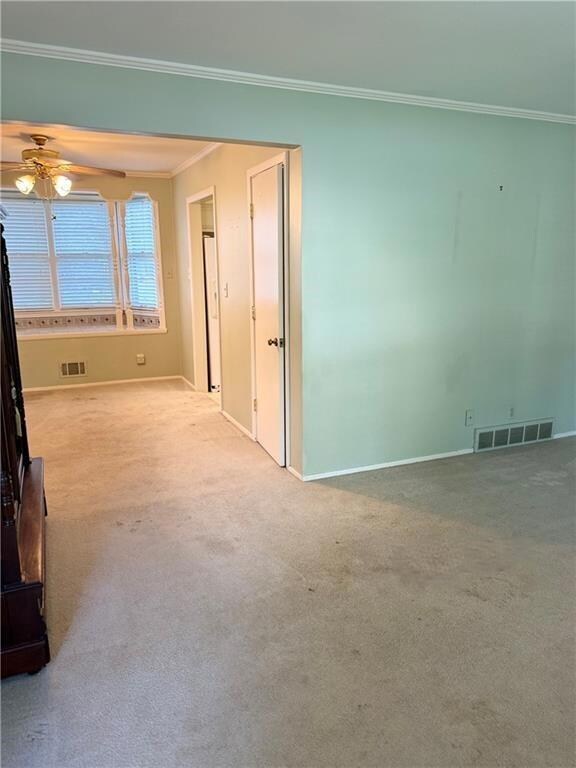 Carpeted spare room with ceiling fan and ornamental molding