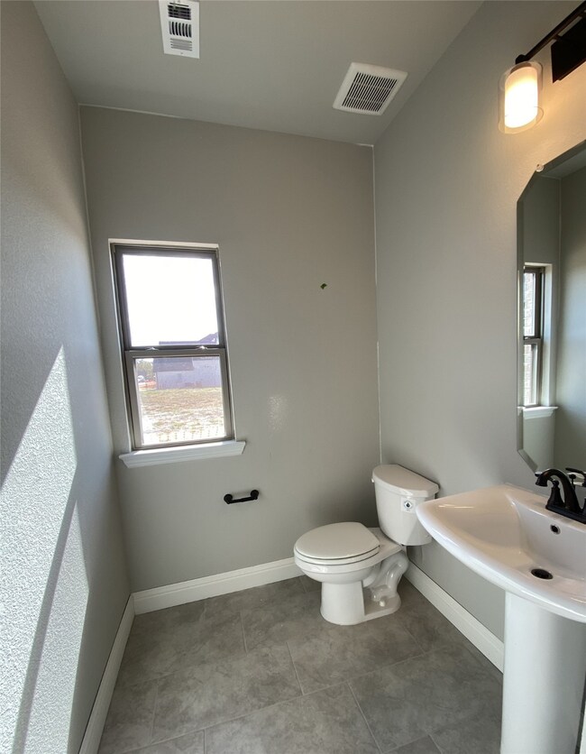 Powder bath downstairs for guests with window for natural light