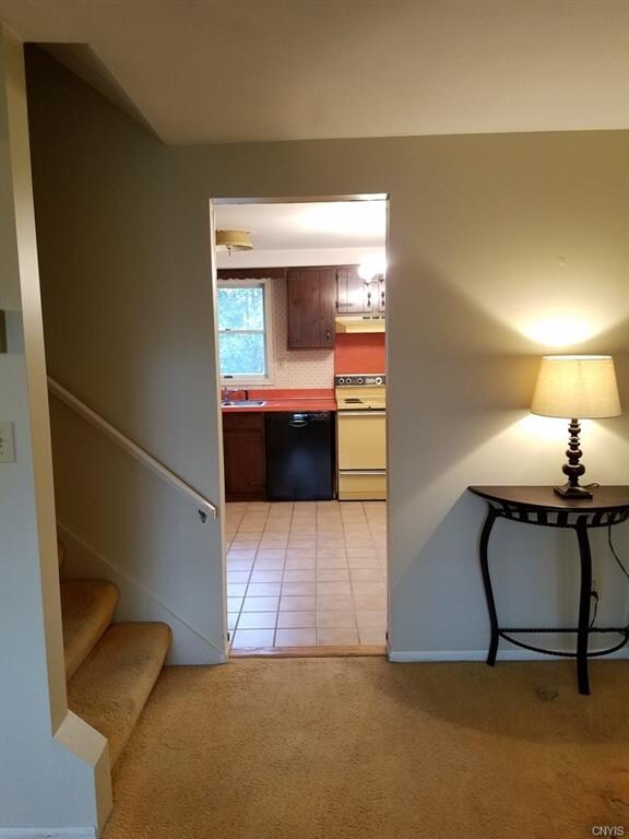 View of kitchen from the living room.  Stairs to t