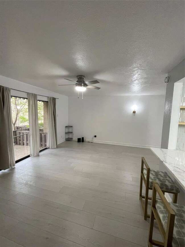 Unfurnished living room with a textured ceiling, c