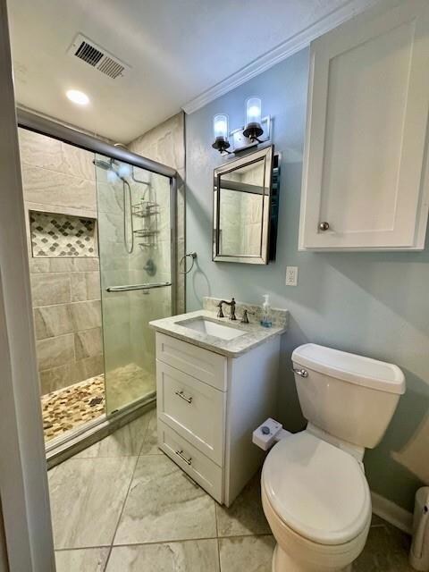 Bathroom with vanity, toilet, a shower with door, 