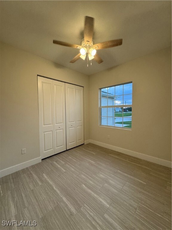 Unfurnished bedroom with a closet, baseboards, and