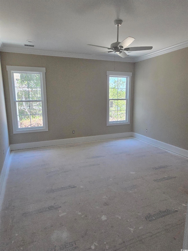 Empty room with a ceiling fan, visible vents, crown molding, concrete flooring, and baseboards