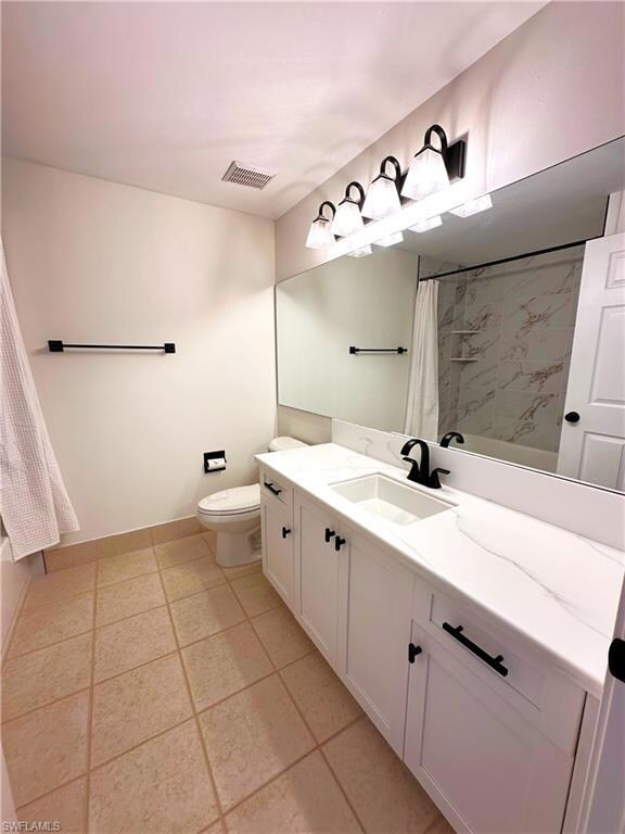 Full bath featuring toilet, vanity, and a shower