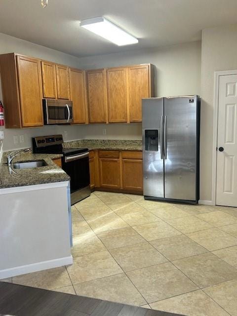 Kitchen with fridge, stove, a sink, brown cabinets