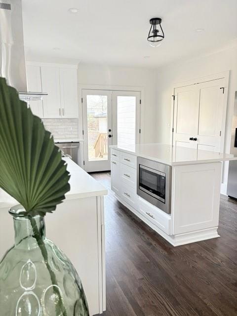 Kitchen featuring light countertops, dark wood fin