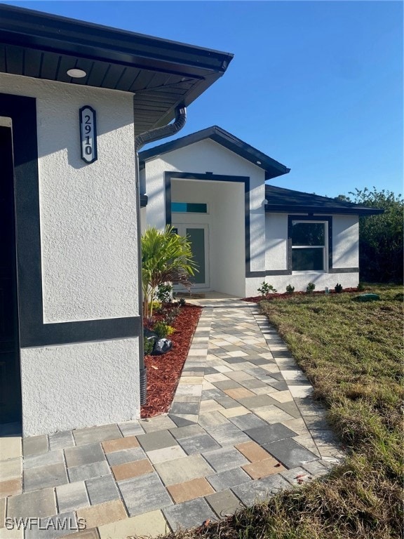 Property entrance featuring stucco siding