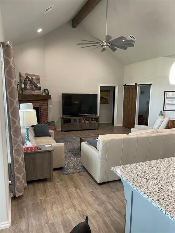 Living room with beam ceiling, hardwood / wood-sty
