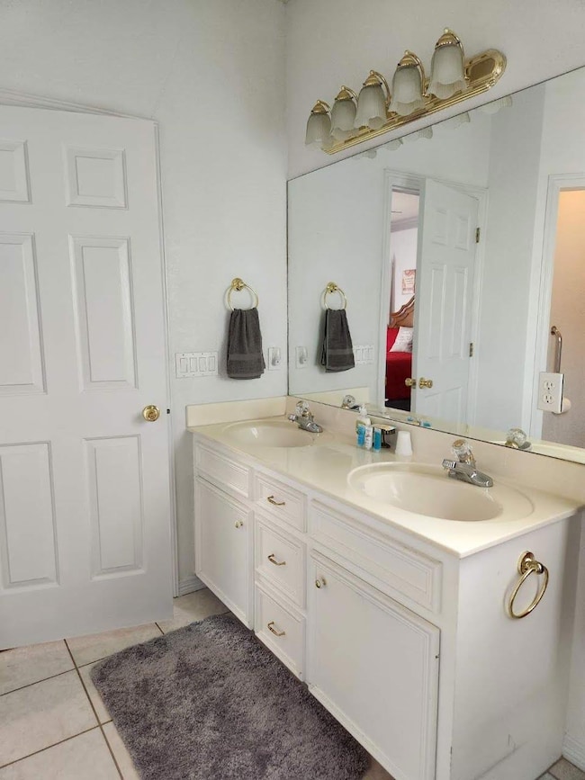 Full bathroom featuring double vanity, tile patte
