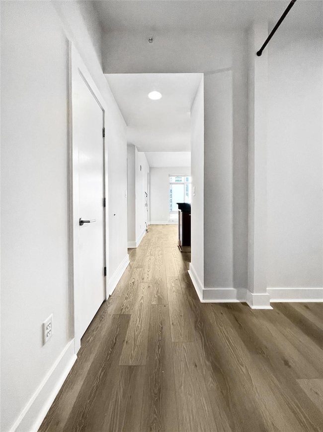 Hallway with wood finished floors and baseboards