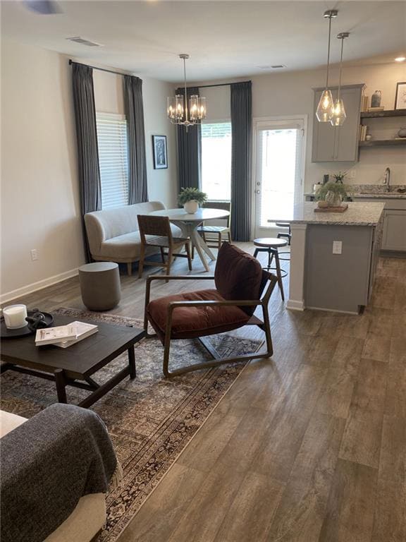 Living area featuring a chandelier and dark wood-style floors