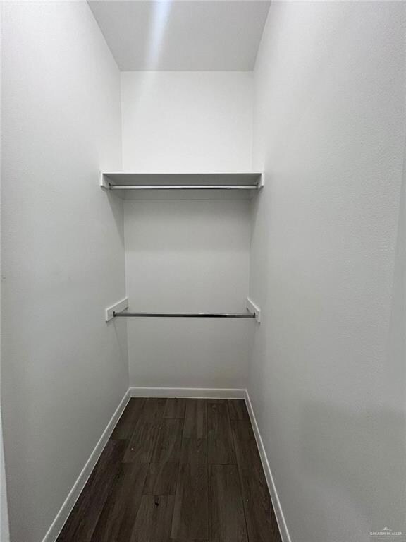 Spacious closet featuring dark hardwood / wood-style floors