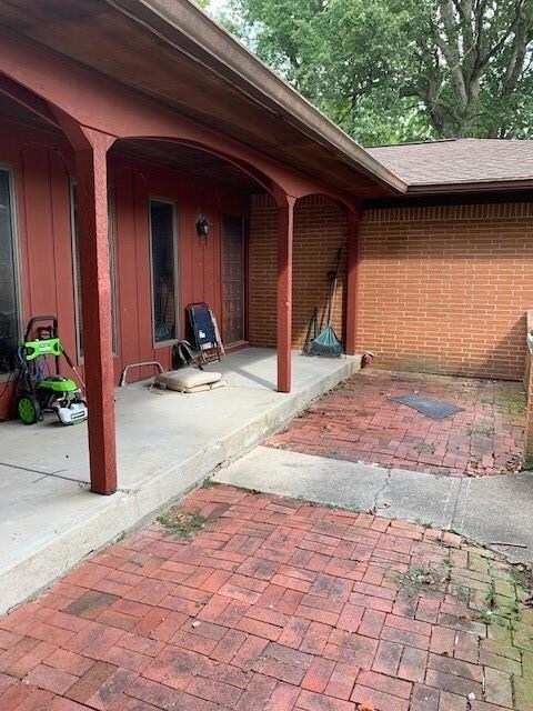 Covered front patio with a brick open patio area