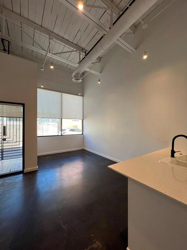 Unfurnished room with a towering ceiling and sink