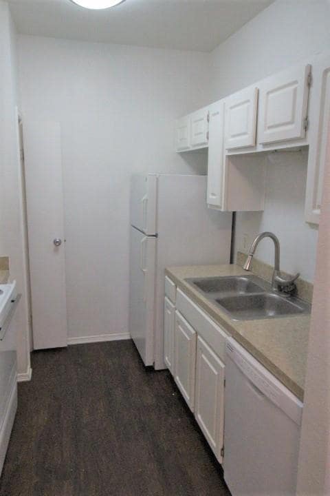 Kitchen with white appliances, white cabinets, and light countertops