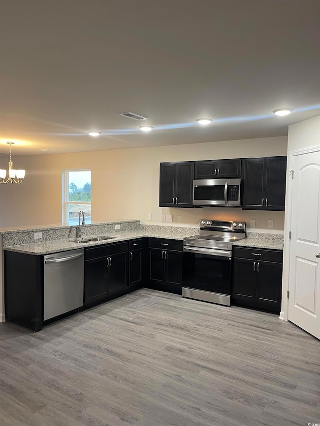 Kitchen featuring sink, light stone countertops, l