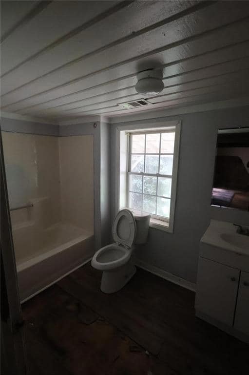 Full bathroom featuring vanity, toilet, wood finished floors, and  shower combination