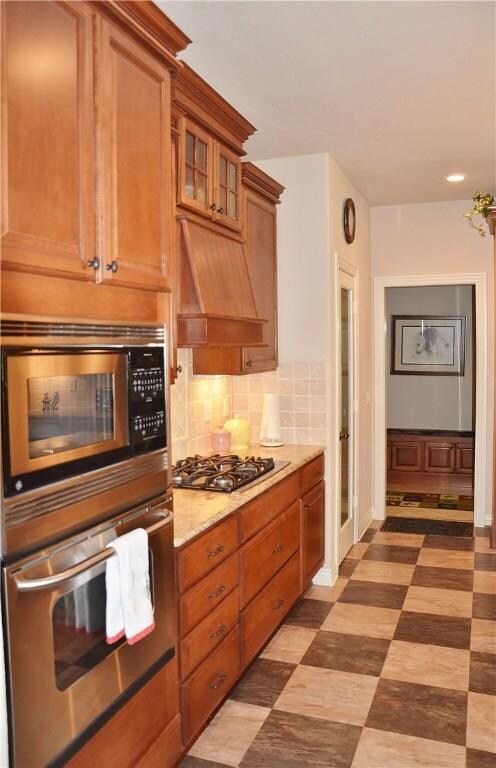 Custom hood over gas cooktop and built-in oven and microwave.