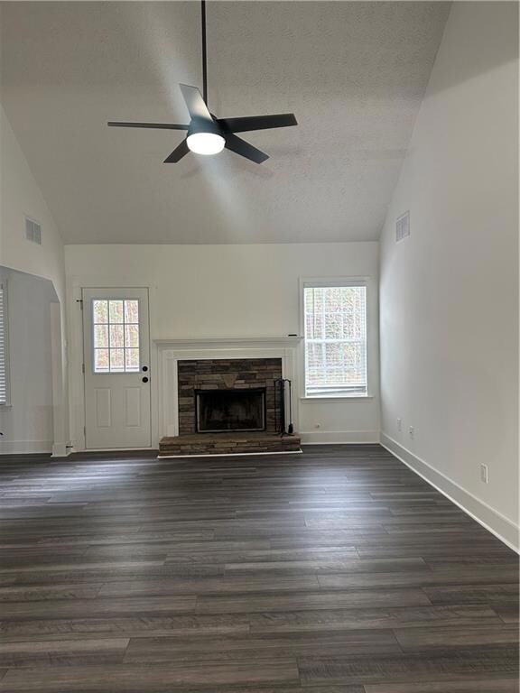 Unfurnished living room with a stone fireplace, ce