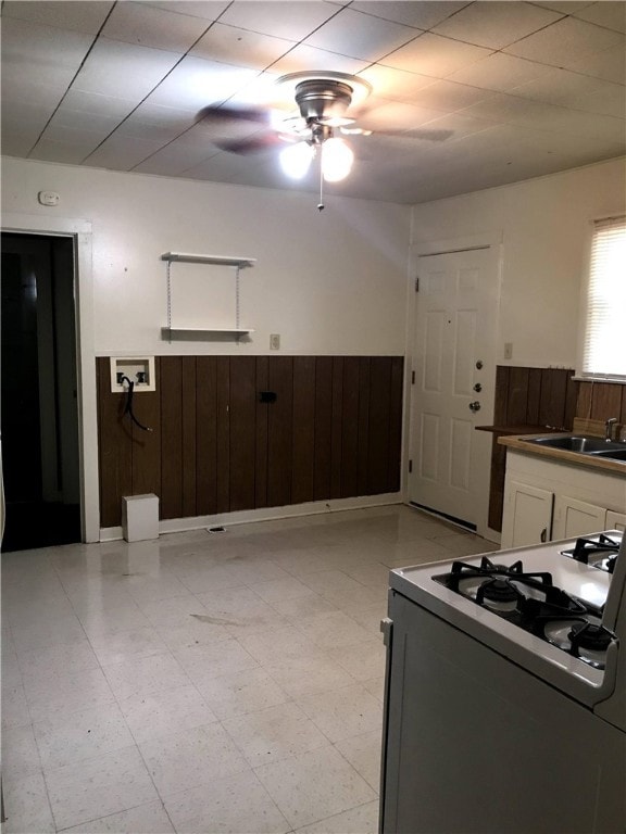 Kitchen with gas range, wainscoting, white cabinet