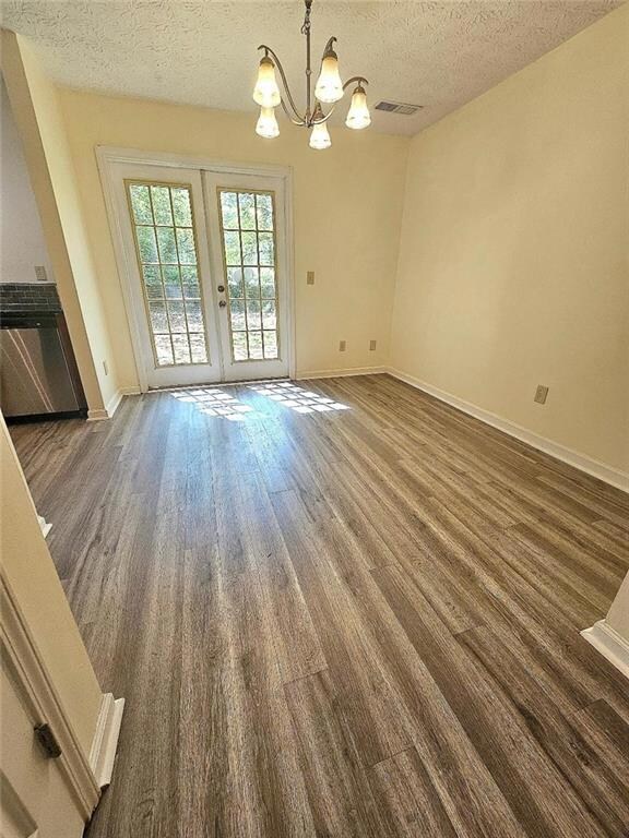 Unfurnished dining area with a textured ceiling, b