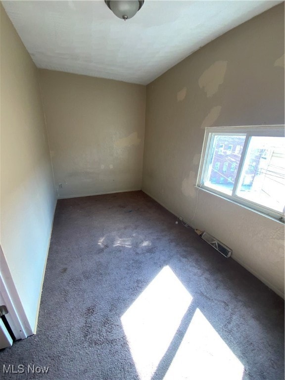 Unfurnished room featuring visible vents and carpet
