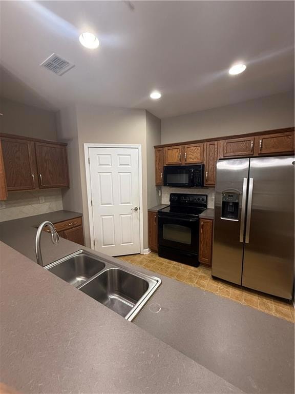 Kitchen featuring stainless steel fridge, range, recessed lighting, and black microwave