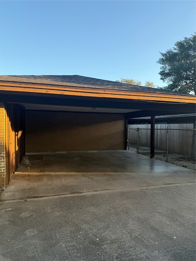 Garage with driveway and an attached carport
