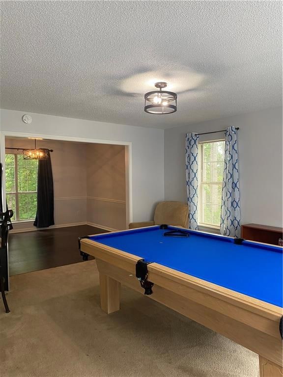 Recreation room with carpet flooring, a textured c