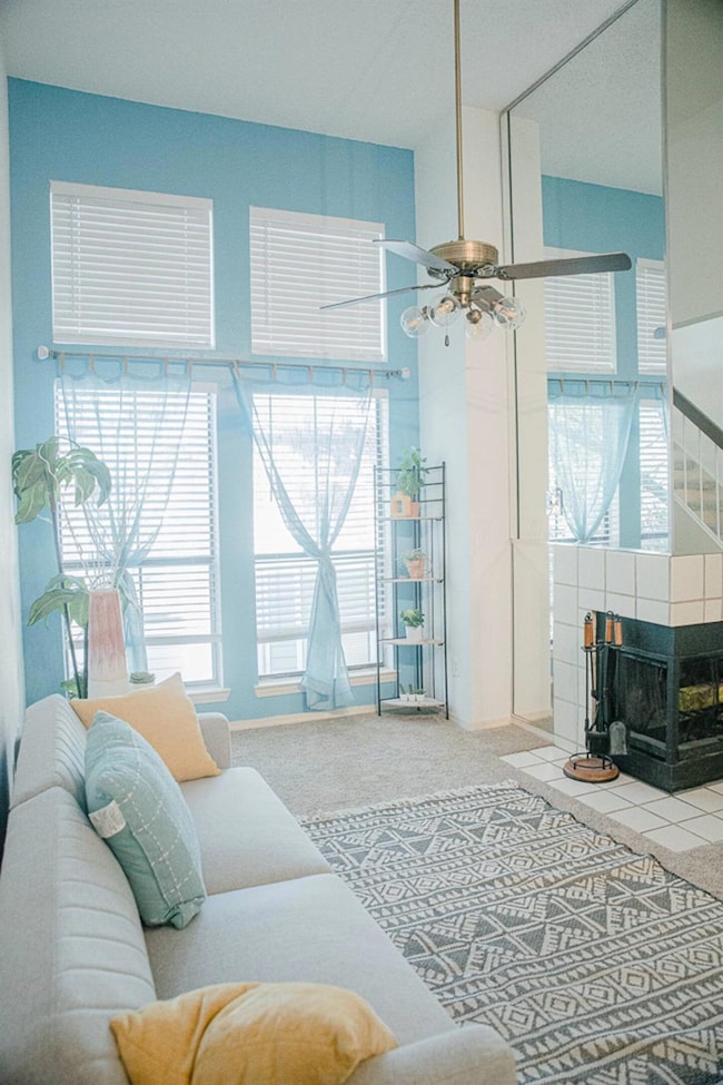 Carpeted living room with a tile fireplace and a c