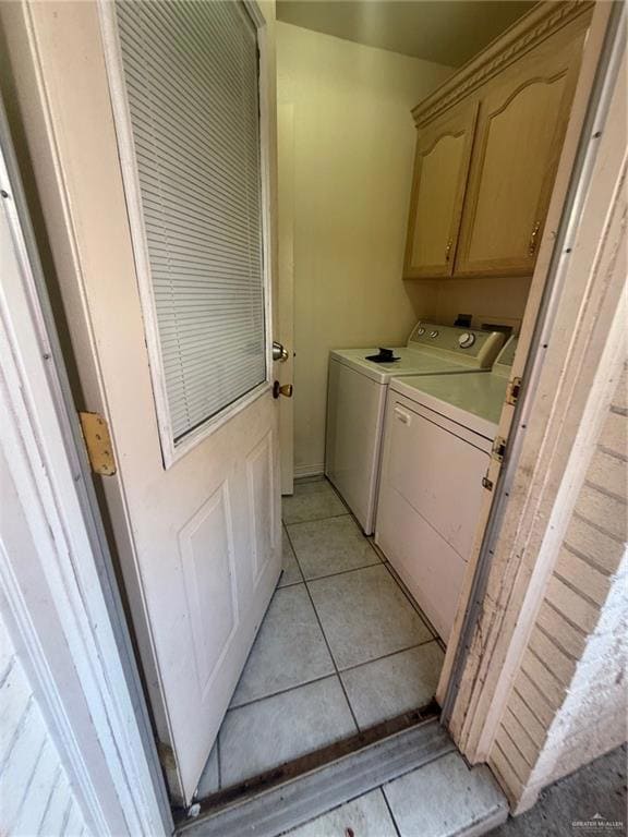 Washroom with washing machine and clothes dryer, cabinet space, and light tile patterned floors
