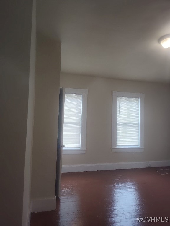 Unfurnished room featuring baseboards and wood fin