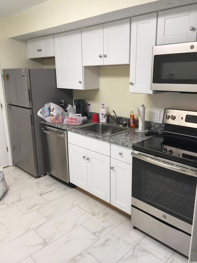 Kitchen with sink, white cabinets, and stainless s