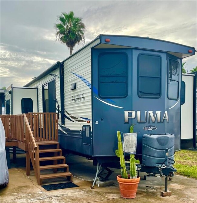 PUMA TRAVEL TRAILER IS STRAPPED DOWN TO CONCRETE PAD.