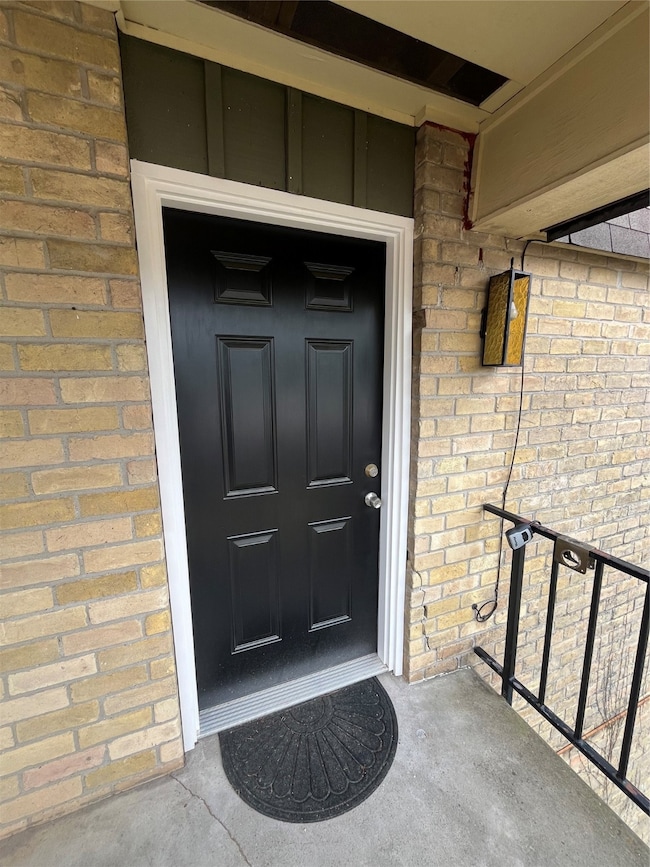 View of exterior entry with brick siding