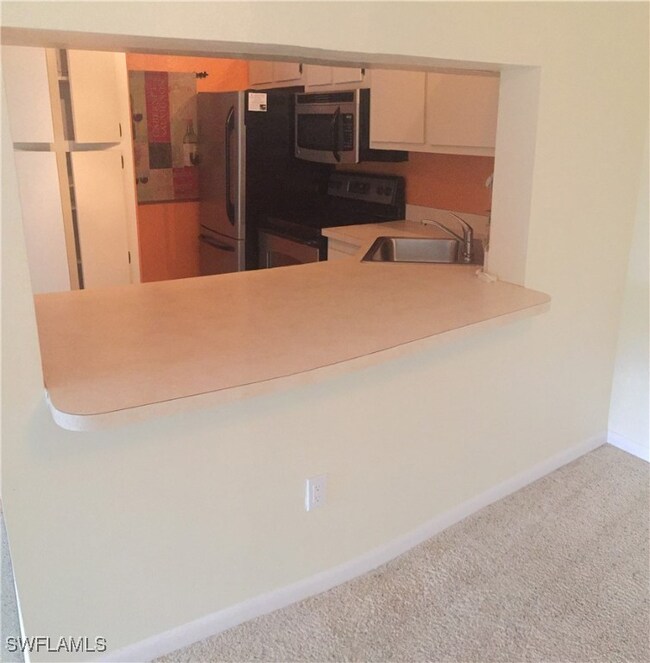 Kitchen featuring cream cabinets, carpet, stainles