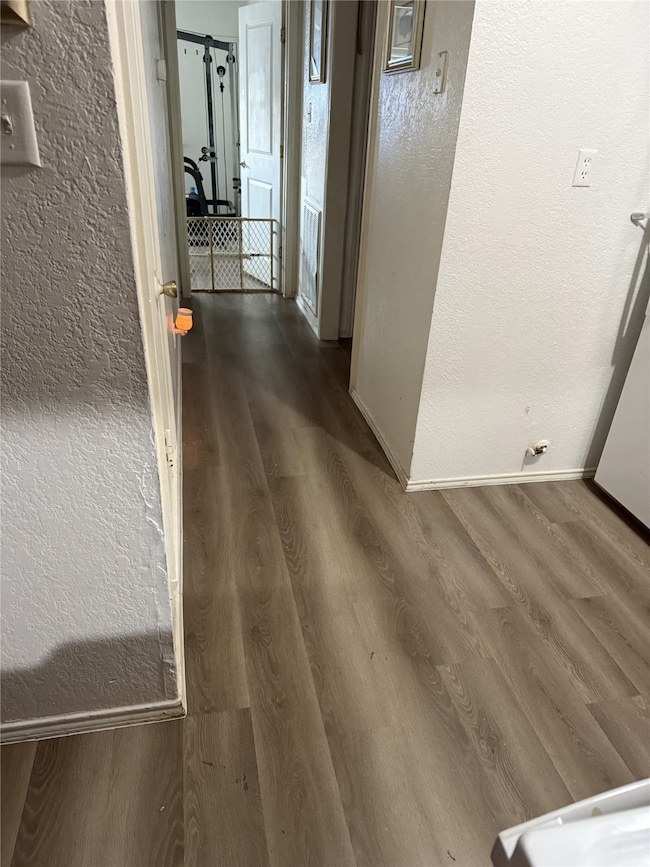 610A - Hallway with a textured wall and Light-wood style luxury plank flooring throughout