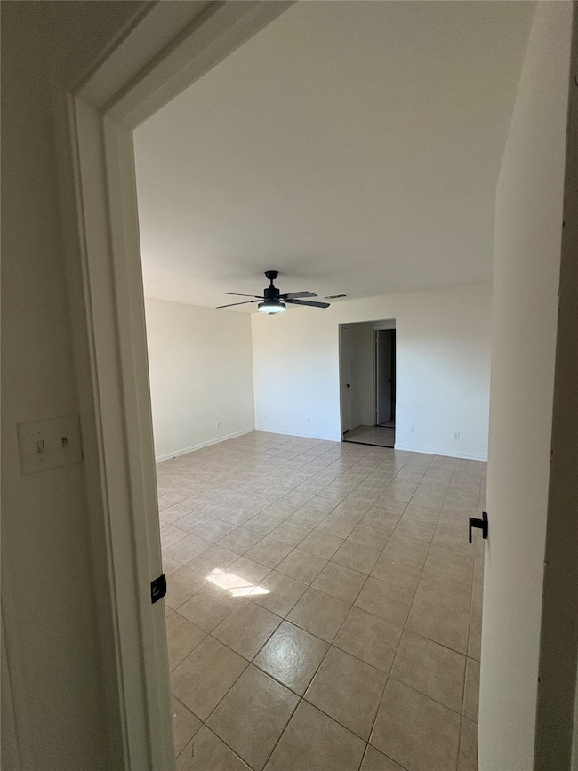 Spare room with ceiling fan and light tile patterned floors
