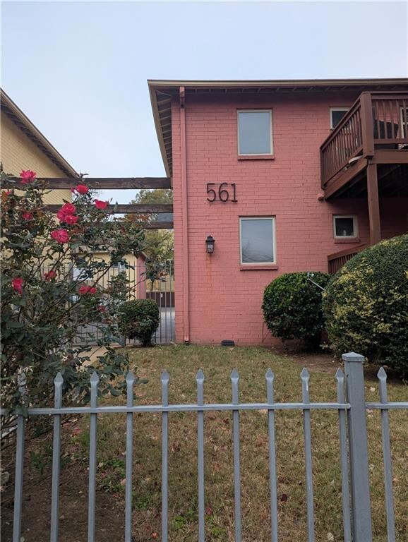 View of side of home featuring brick siding, fence