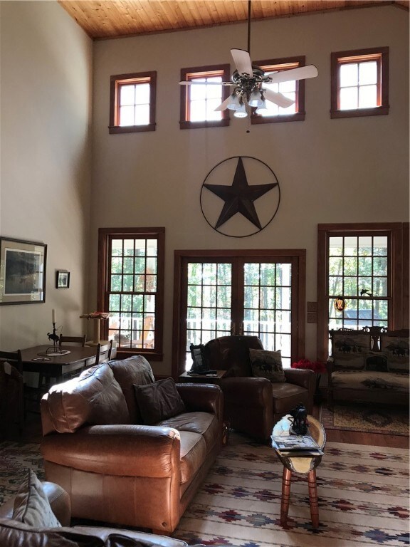 View of two story living room with doors to covere