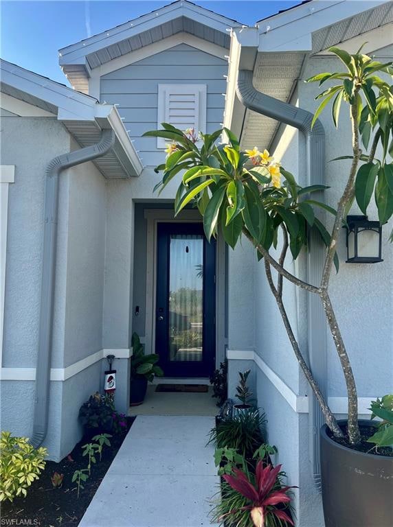 View of exterior entry featuring stucco siding