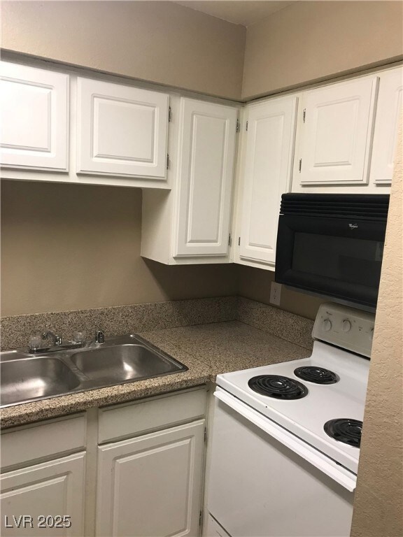 Kitchen with white range with electric cooktop, bl