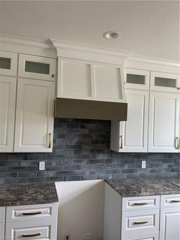 White cabinetry, backsplash, and custom vent cover
